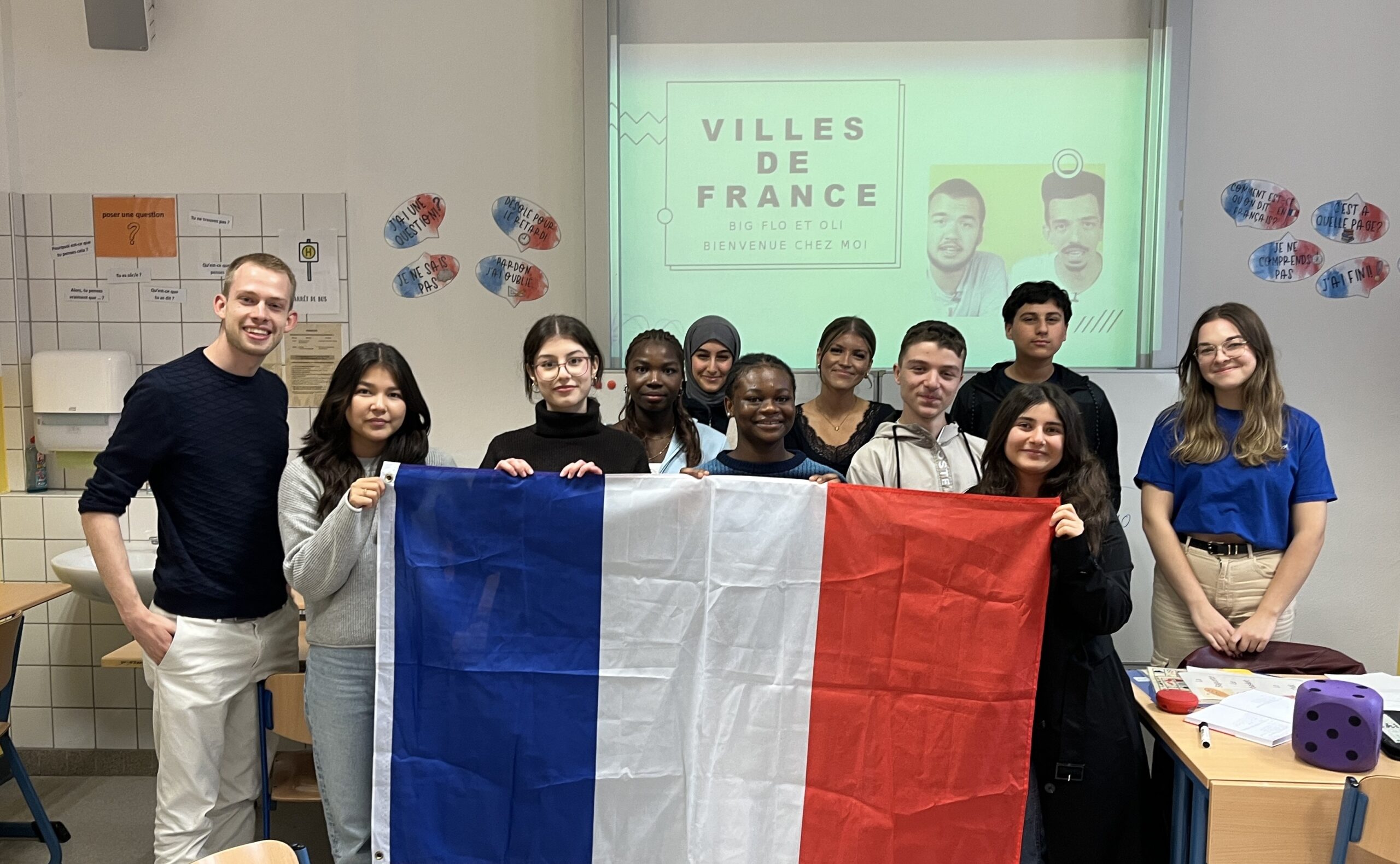 EF-Schüler*innen halten die Tricolore, die französische Nationalflagge.