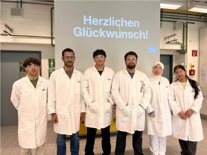 Schüler mit Kittel und Schutzbrille an der Uni